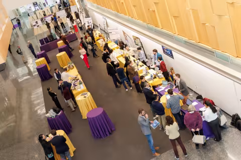 Aerial view of people gathered for a conference, poster presentations and technology demonstrations inside UAlbany's ETEC building.