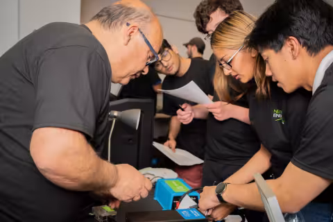 People in safety glasses gather in a laboratory for a training on energy storage technologies
