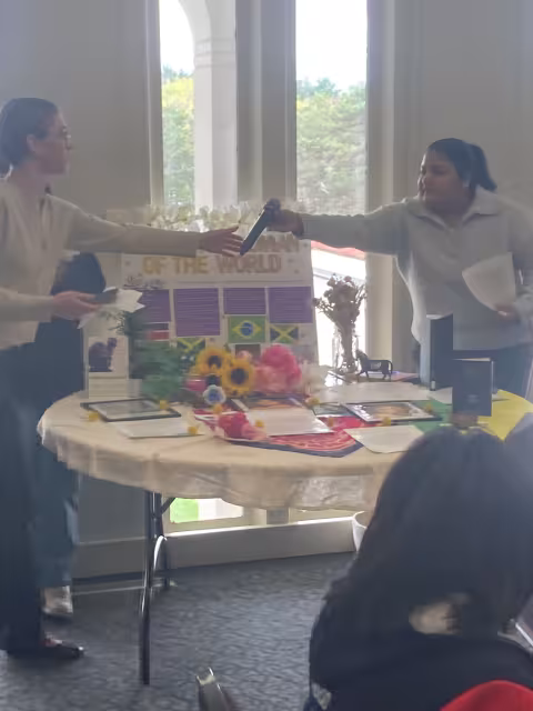 Two students passing each other a microphone.