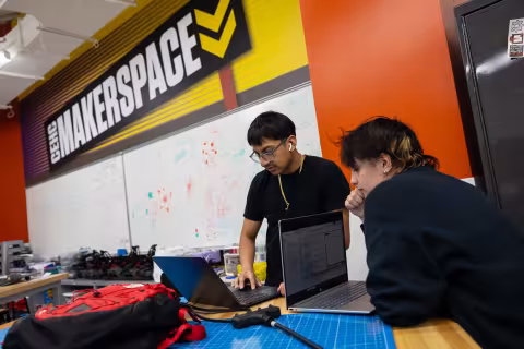 Students view a laptop from inside UAlbany's Makerspace