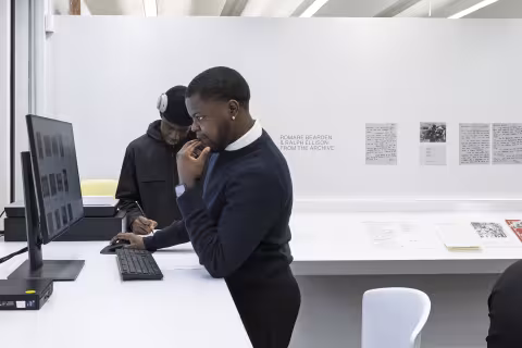 Two students using a computer at a standing desk