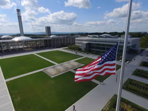 An American flag flies in front of UAlbany's Massry School of Business.