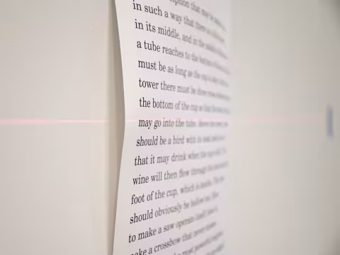 Print out of a poem on the wall with a laser level line through it