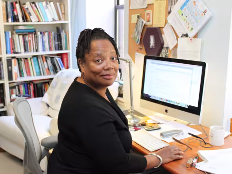 Poet Erica Hunt in front of a computer