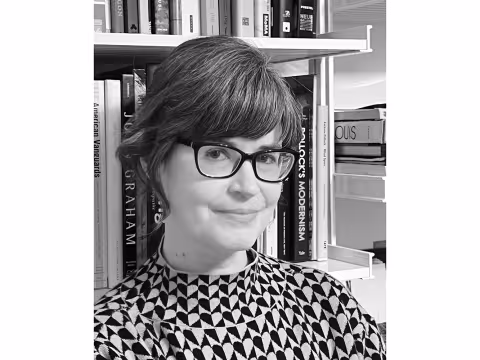 Black and white photo of historian Molly Warnock in front of a bookshelf