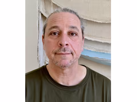 Artist Howard Schwartzberg in front of a torn canvas 