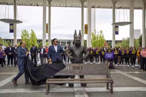 Joe Bonilla, president of the Alumni Association Board of Directors, and UAlbany President Havidán Rodríguez unveil the Damien statute.