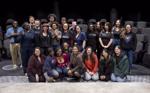 The crew of "The Drunken City" pose for a group photo inside a theatre at UAlbany's performing Arts Center