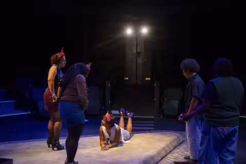 Two actors, one of them lying down, perform "The Drunken City" inside a theatre at UAlbany
