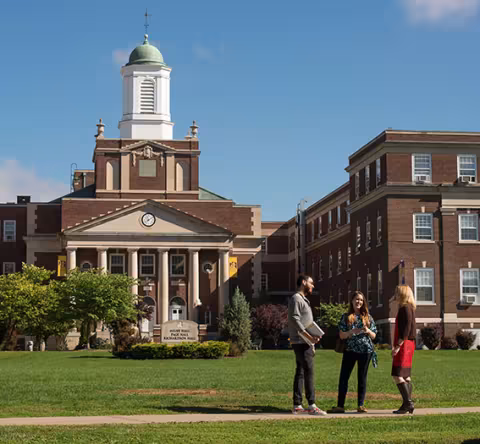 A group of students chat on the lawn in front of UAlbany's Downtown Campus.