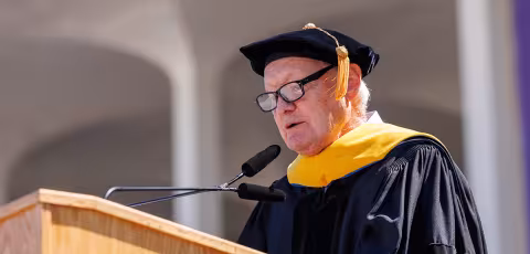A speaker stands at the podium to speak during commencement.