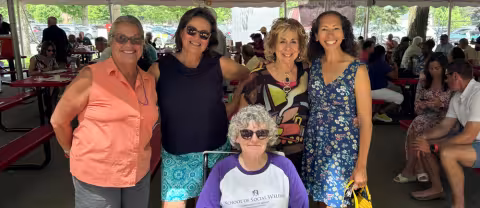 Alumni and staff from the UAlbany School of Social Welfare pose for a photo under a tent at Saratoga Race Course.