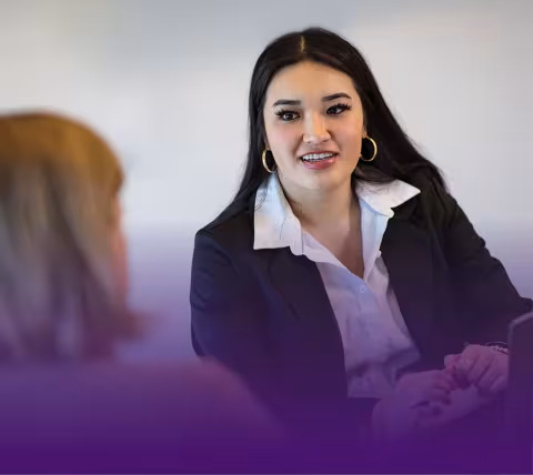 Student in business attire speaks with a person.