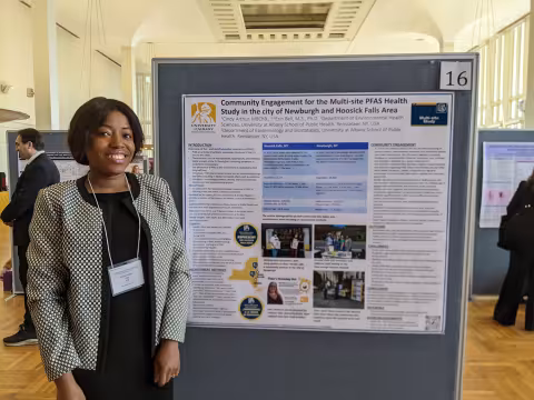 Cindy stands next to her poster.