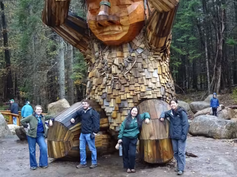 Students stand for a picture in front of a statue at the Wild Center in the Adirondacks.