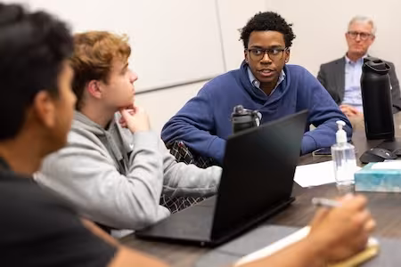 Students and faculty brainstorm in a meeting