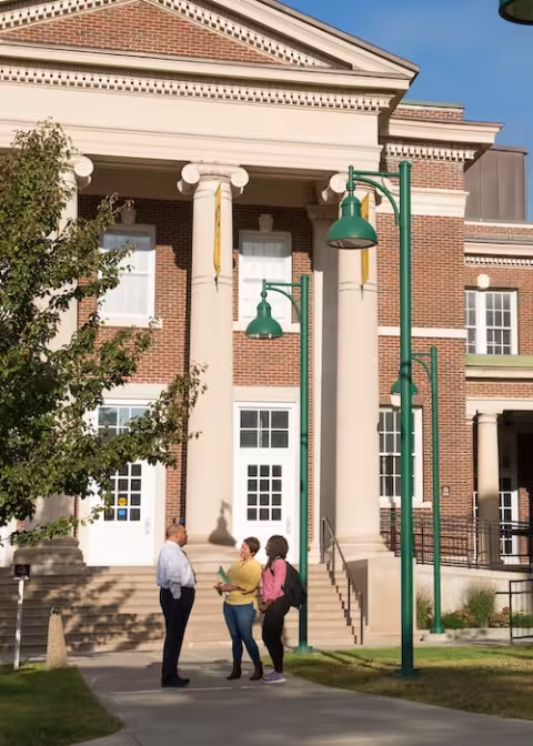 People stand before Milne Hall