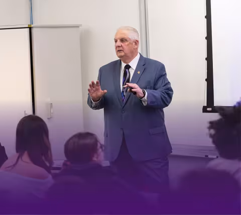 A professor teaching in the Massry School of Business classroom.