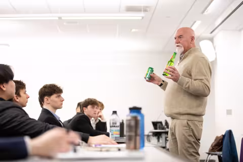 Norm Snyder talking to students and holding Reed's products