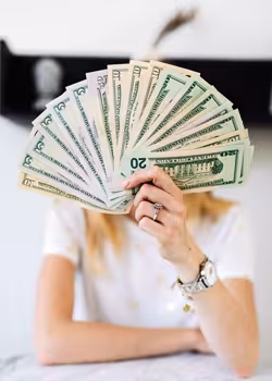 A person holding out a fan of U.S. paper money.