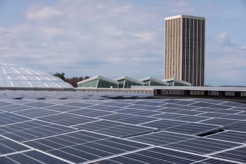 Solar panels on top of the Campus Center building, with one of the residential towers in the background.