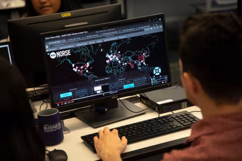 Student working on computer project in Digital Forensics lab 