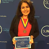 Stuti Misra holding a SUNY award