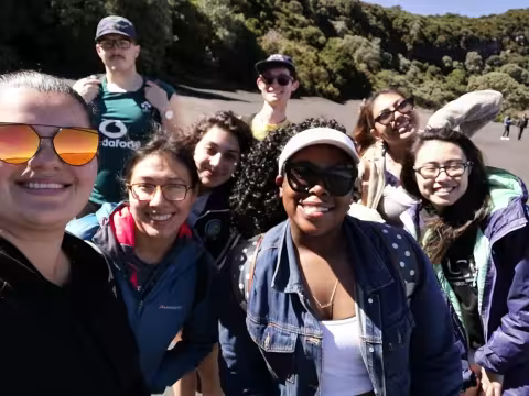 A group of students pose for a selfie outside. 