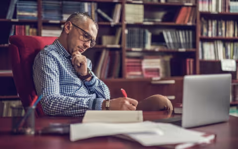 A man making notes in his home office