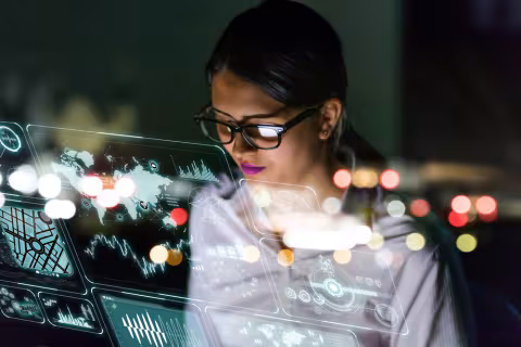 A person viewing multiple computer monitors displaying charts and graphs.