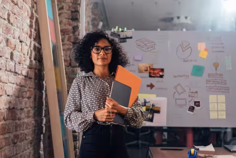Young professional standing in front of a white board