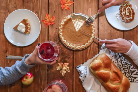 A table set with various plates of food and pies, showcasing a festive meal ready to be served.