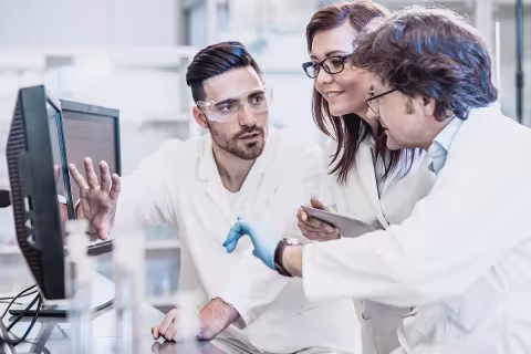 Three researchers working in a chemistry lab