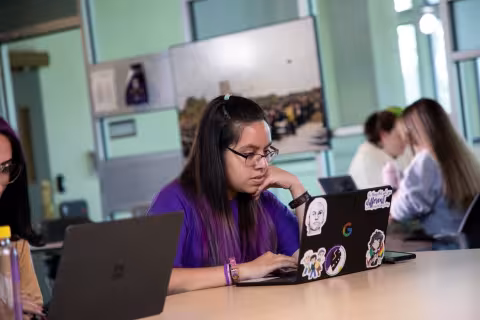 A student focuses as she works on a laptop inside the Transfer and Commuter Lounge in UAlbany's Campus Center.