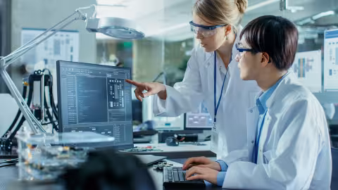 Two scientists reviewing data on a computer