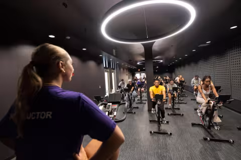 A group exercise instructor leads an indoor cycling class inside The Well at Colonial.