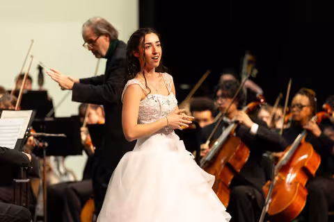 Performer singing with the University Orchestra.