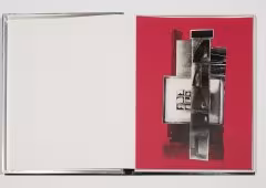 An open notebook. The left page is blank and the right page is red with back and white graphics.