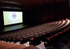 large theatre with many seats and slide with projection on stage