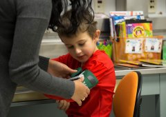 Boy wearing red shirt receives a check up from an Upstate KIDS researcher