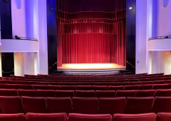 partial shot of intimate concert hall with red seats and curtains