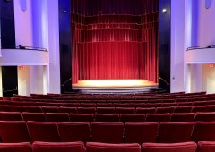 partial shot of intimate concert hall with red seats and curtains