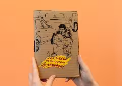 Two hands holding a small, brown notebook.