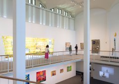 Visitors walk through the 2025 Master of Fine Arts Thesis Exhibition space.