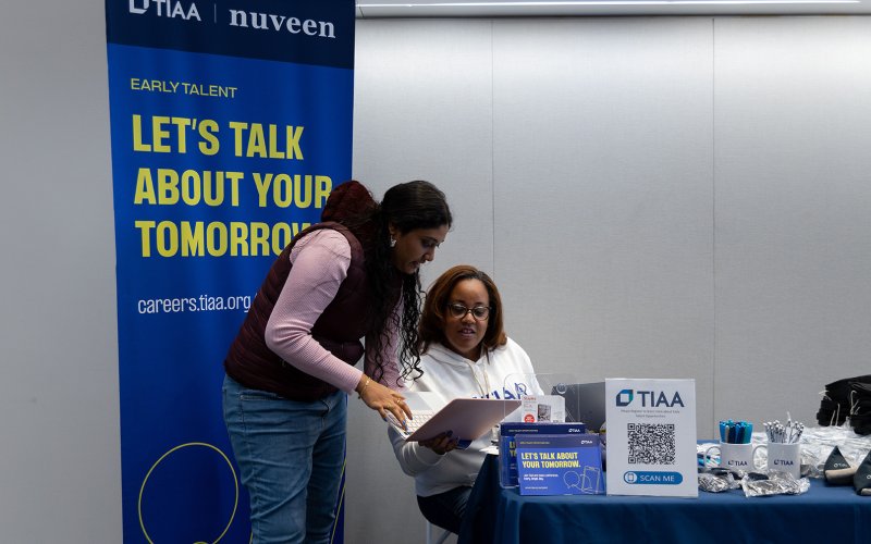 A student holds a laptop during a meeting with TIAA's Laurie Brown-Goodwine at the State of Grace Conference.