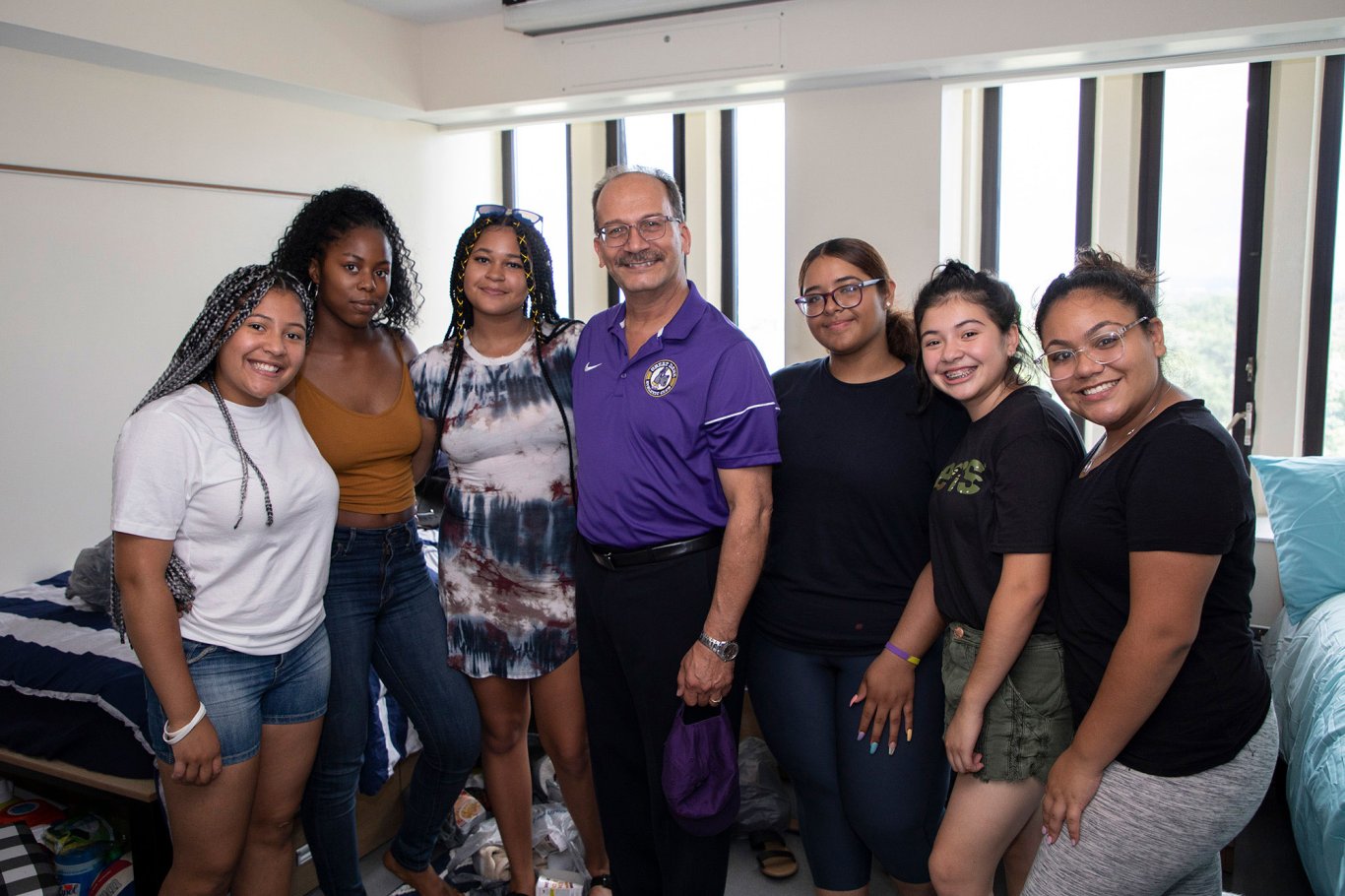 University President standing with a group of students during move in.