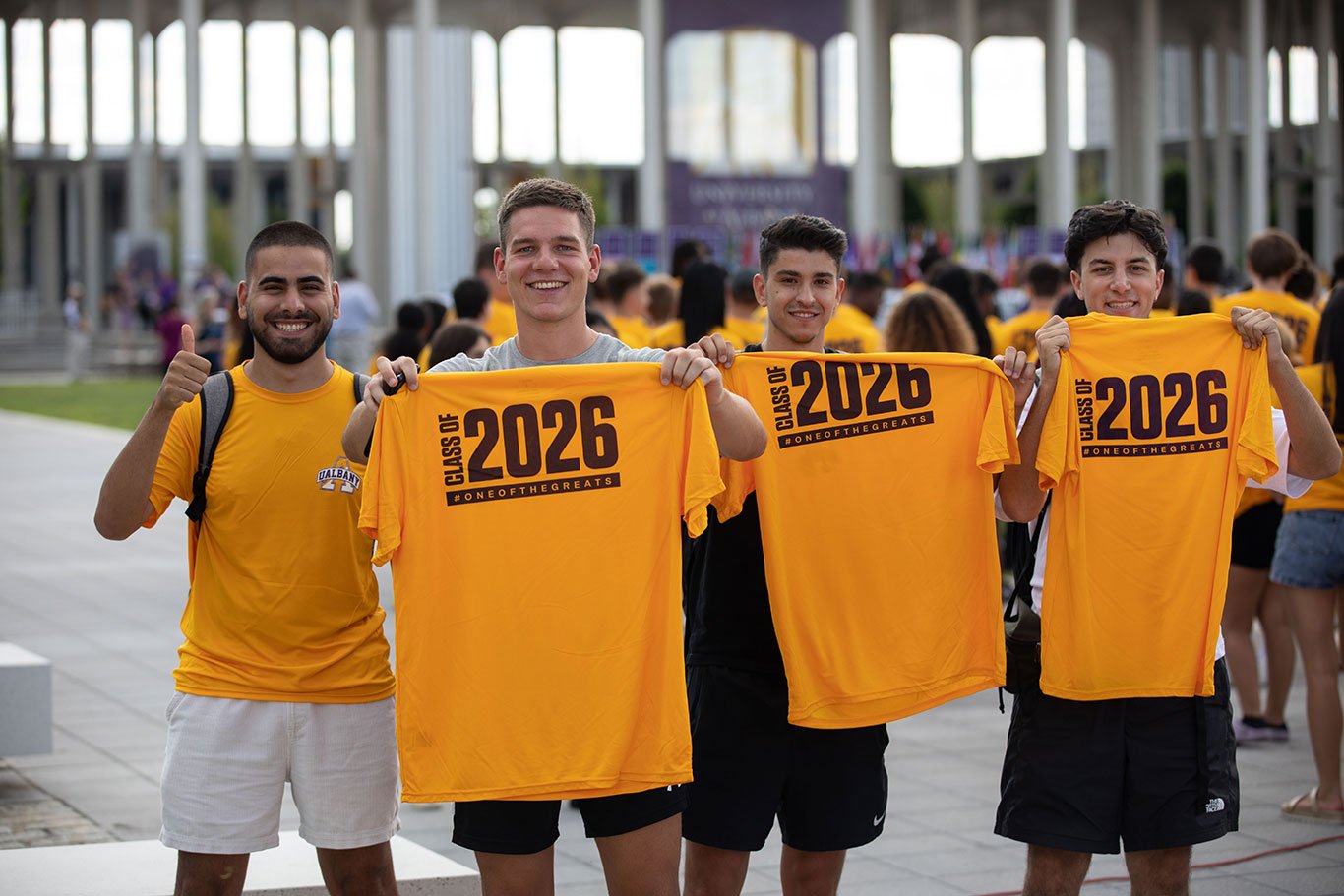 Four students at convocation holding up Class of 2026 shirts.