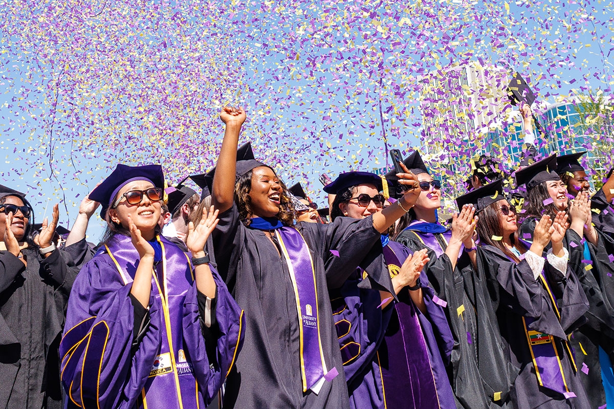 A group of students at the graduate ceremony celebrating in confetti.