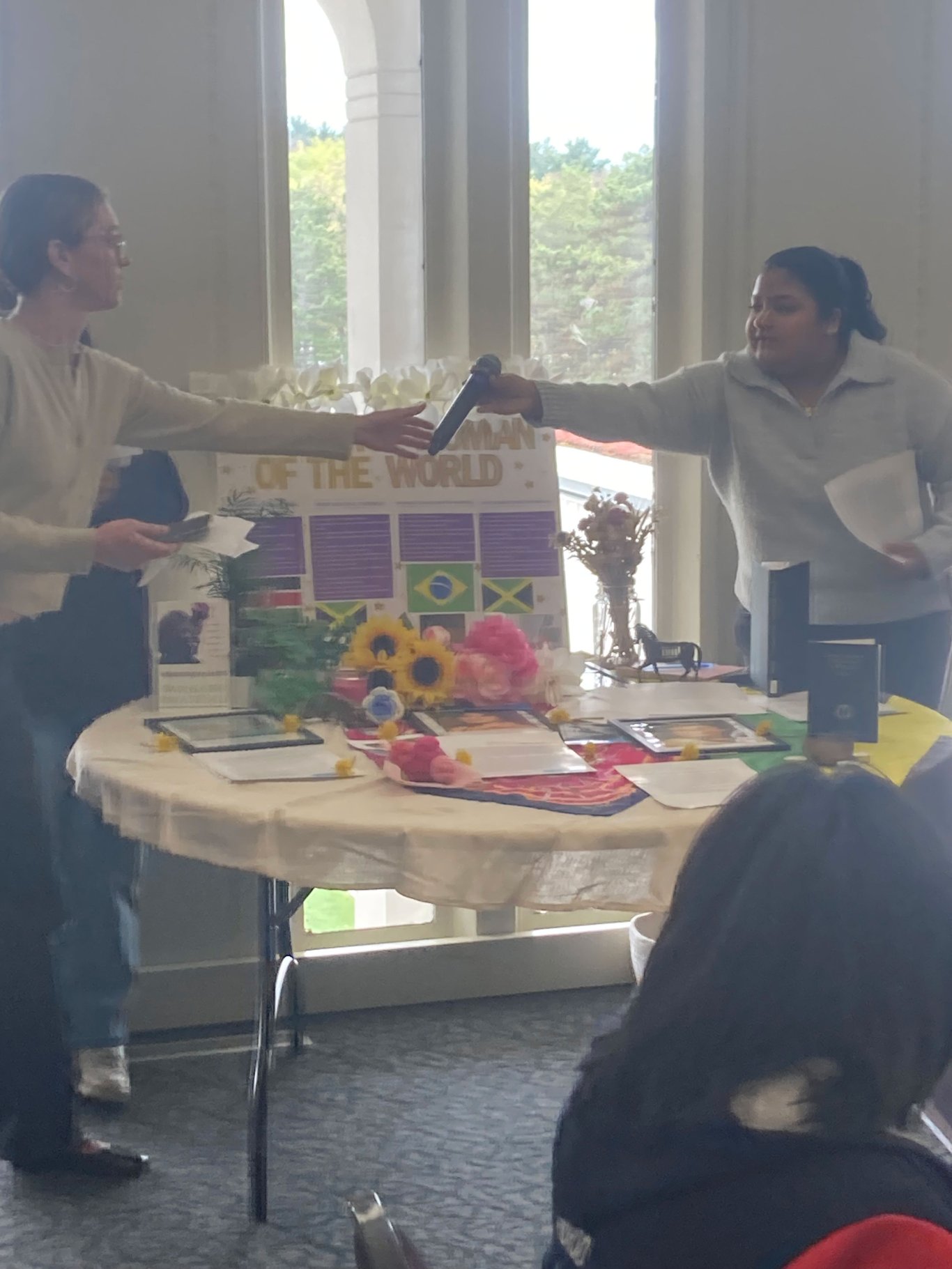Two students passing each other a microphone.