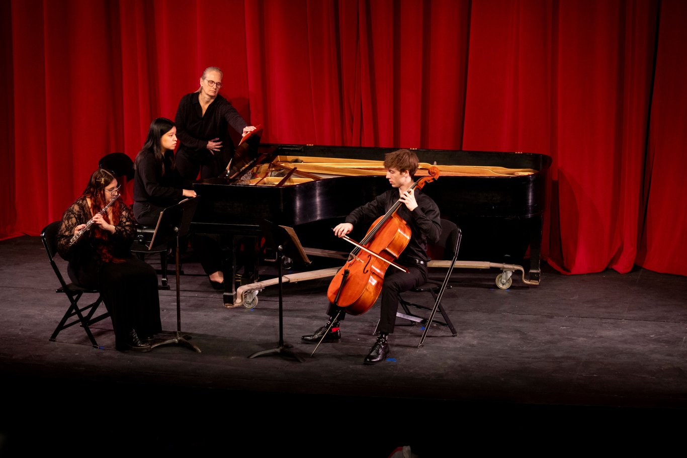 Three students playing a piano, cello and flute perform a song at Showcase.